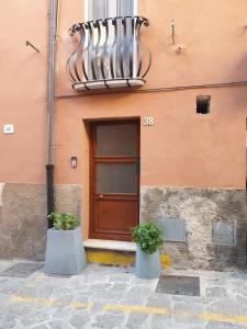 un edificio con una puerta y dos plantas delante de ella en Lovely Corner, en Porto Santo Stefano