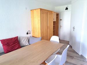 sala de estar con mesa de madera y sillas blancas en Studio au coeur d'Avoriaz - 4 pers - vue splendide, en Avoriaz