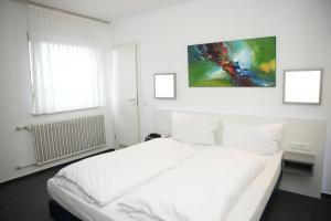 ein weißes Schlafzimmer mit einem großen Bett mit weißer Bettwäsche in der Unterkunft Weber Residenz in Mannheim