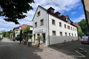 un bâtiment blanc sur le côté d'une rue dans l'établissement Design Apartment im alten Schloss Deidesheim, à Deidesheim