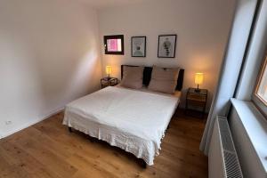 - une chambre avec un lit blanc et deux lampes dans l'établissement Design Apartment im alten Schloss Deidesheim, à Deidesheim