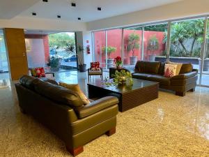 a living room with two leather couches and a coffee table at Penthouse Espectacular Vista Cd A.C. WiFi 300mbps in Guadalajara