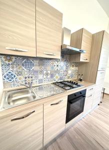 a kitchen with a sink and a stove at Athena Apartments Levante in Porto Cesareo