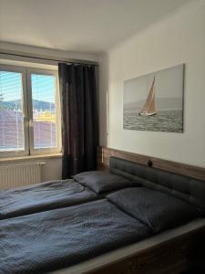 a bedroom with a bed and a sailboat in the window at Zum Breyer BNB City Apartment in Baden