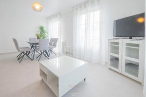 een witte woonkamer met een tv en een tafel bij *Disneyland-Paris*4pers, Wifi, Parking in Serris