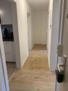 een hal van een lege kamer met een houten vloer bij Charmante Wohnungen direkt in der Stadtmitte in Andernach