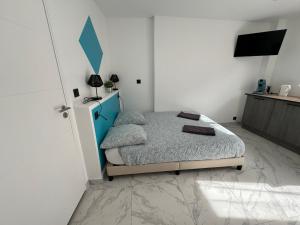 1 dormitorio con 1 cama con cabecero azul en La maison de Giulia Menton, en Menton