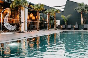 una piscina di fronte a un edificio con palme di Rubens Hotels & SPA a Vila Nova de Gaia