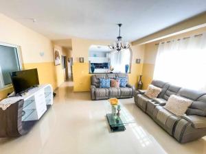 sala de estar con sofá y TV en Zeyden Place Apt 2, en Praia