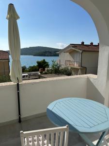 a patio with a blue table and an umbrella at Apartments Perina in Tisno