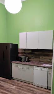 a kitchen with white cabinets and a microwave on a counter at Pension I in Berlin