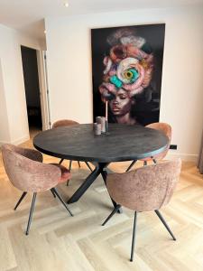 uma mesa preta com cadeiras num quarto com uma pintura em Boulevard 3F em Arnhem