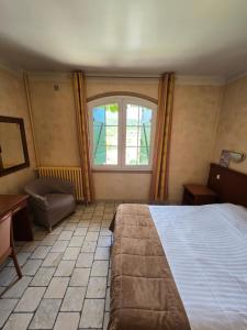 um quarto com uma cama grande e uma janela em Auberge les Aromes em Grasse