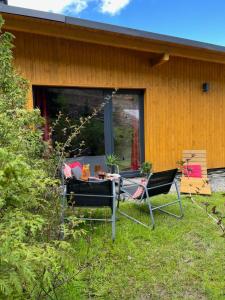 una mesa y dos sillas frente a una casa en Apartamenty i Las, en Brenna