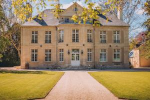 Bény-sur-MerHôtel 4 étoiles Château - Domaine de Coeurmandie的前面有一条小路的大房子