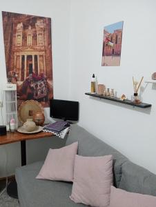 Its your choice hostel في وادي موسى: غرفة معيشة مع أريكة وطاولة مع الكمبيوتر المحمول