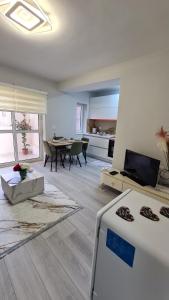 a large living room with a table and a kitchen at Dei Cozy Apartment in Shkodër