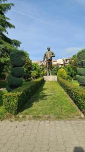 a statue of a man standing in a park at Dei Cozy Apartment in Shkodër