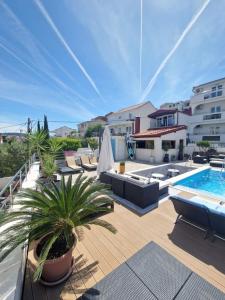 un patio avec des chaises et une piscine dans l'établissement Apartments Silva with a view of sea, à Trogir