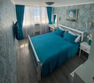 een slaapkamer met een blauw bed en blauwe gordijnen bij Shalanda in Odessa