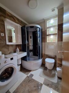 a bathroom with a washing machine and a toilet at SAN in Čačak