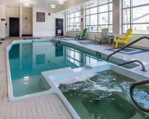 une grande piscine avec bain à remous dans un bâtiment dans l'établissement Quality Inn, à Moncton