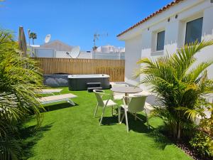 einen Hinterhof mit einem Tisch und Stühlen sowie einem Tisch und Stühlen in der Unterkunft MAR BIANCO - Gay Men Only in Maspalomas