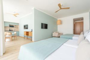 1 Schlafzimmer mit einem großen Bett und einer Küche in der Unterkunft Studios by Aqua Natura Hotels in Porto Moniz