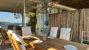 un tavolo in legno e sedie su una veranda con vista sull'acqua di stunning Views over Cadaques a Cadaqués