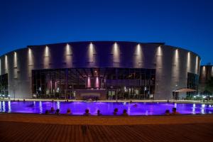 ein großes Gebäude mit Pool in der Nacht davor in der Unterkunft Flóra Panzió in Miskolctapolca