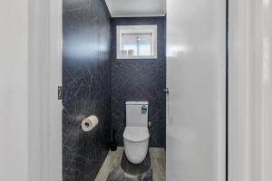 a bathroom with a white toilet in a stall at Newly Renovated House near Melbourne Airport in Melbourne