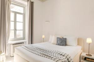 a white bedroom with a white bed and a window at Hydra Hotel in Hydra