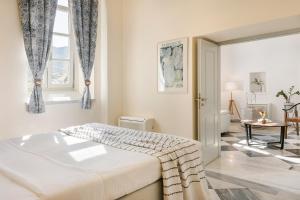 a white bedroom with a bed and a window at Hydra Hotel in Hydra