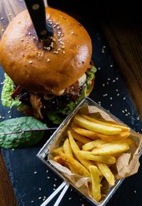 Ein Sandwich und ein Behältnis Pommes Frites auf dem Tisch. in der Unterkunft Solina Resort in Polańczyk