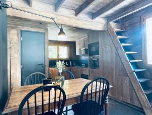 uma cozinha com uma mesa e cadeiras de madeira e uma escadaria em Le Chalet Georges em Chamonix-Mont-Blanc