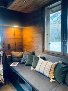 um sofá sentado num quarto com uma janela em Le Chalet Georges em Chamonix-Mont-Blanc