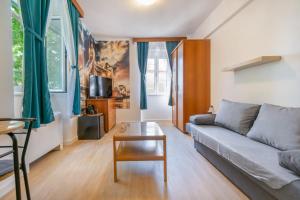 uma sala de estar com um sofá e uma mesa em Bed and Breakfast Palac em Baška Voda