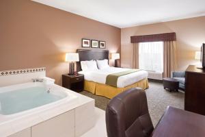 um quarto de hotel com uma cama e uma banheira em Holiday Inn Express Hotel & Suites Van Wert, an IHG Hotel em Van Wert