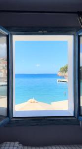 ein Fenster mit Blick auf den Strand in der Unterkunft PARALIA Stoudios in Parga