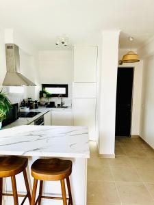 una cucina con bancone bianco e 2 sgabelli di Sea View, Beach 3 minutes ad Albufeira