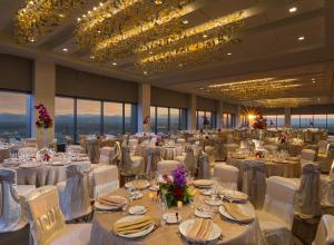 een grote feestzaal met witte tafels en stoelen bij Grand Hyatt Denver in Denver