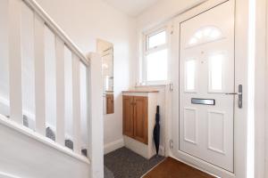 a hallway with a white door and stairs at 4 bedrooms house for working Professionals in Southampton