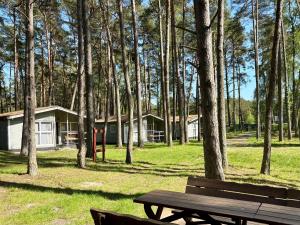 einem Picknicktisch und einer Bank vor einem Haus in der Unterkunft Leśna Przystań in Pobierowo