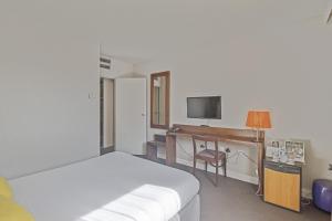 - une chambre avec un lit et un bureau avec une télévision dans l'établissement Hôtel Provence, à Draguignan