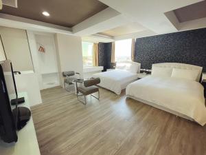 a hotel room with two beds and a flat screen tv at 幸福星空時尚旅館 in Luodong