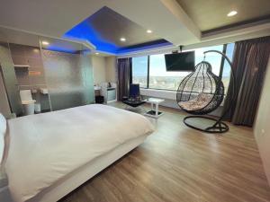 a bedroom with a large bed and a swing at 幸福星空時尚旅館 in Luodong