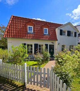 uma casa branca com um telhado vermelho e uma cerca em Haus mit 110qm und Garten 150m zum Wasser em Stralsund