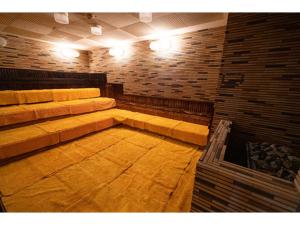 Pokój z kanapą i ceglaną ścianą w obiekcie Male Only Capsule Hotel & Sauna G-topia - Vacation STAY 70068v w mieście Funabashi