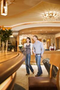 a man and a woman standing in a restaurant at Hotel Chalet Tianes - Alpine Relax in Castelrotto