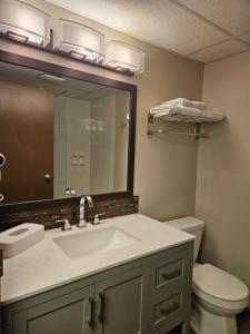 bagno con lavandino, servizi igienici e specchio di Super 8 by Wyndham Spruce Grove a Spruce Grove